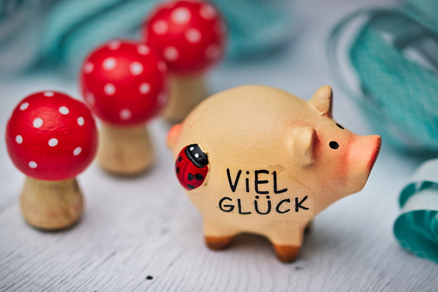 Handmade ceramic pig figurine with Viel Gluck text and red mushroom decorations
