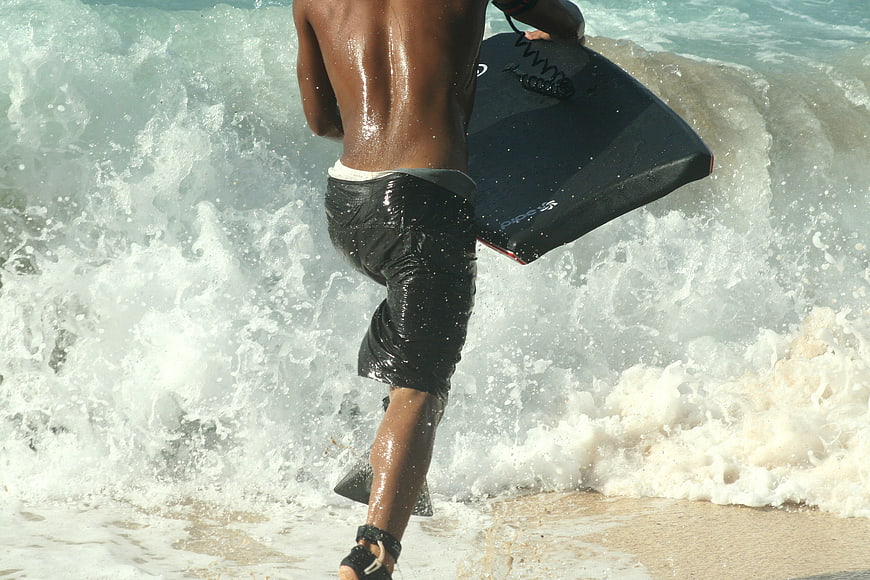 Surfer Running into Ocean Waves with Bodyboard