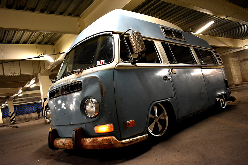Customized vintage blue VW high-top bus in parking garage