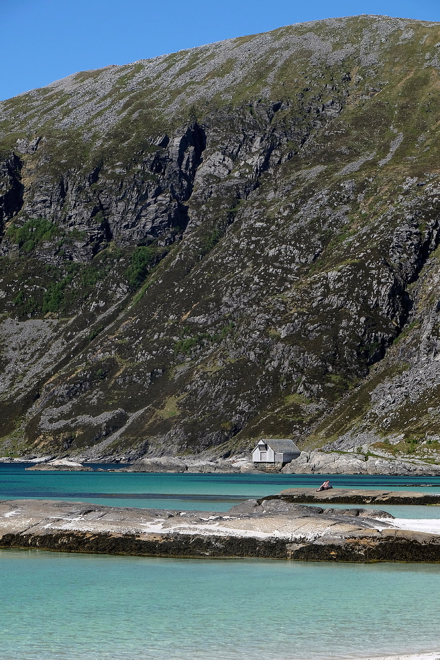 Solitary Cabin on Rocky Coastline with Turquoise Water