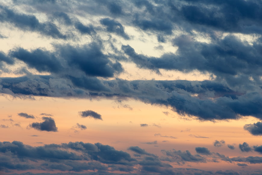 Dramatic sunset sky with dark clouds and warm orange glow