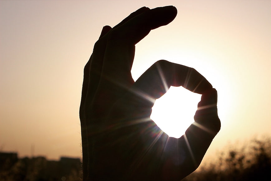 Hand Silhouette Making OK Sign Against Sunset Sky