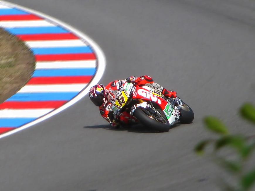 Motorcycle racer leaning into a curve on a race track