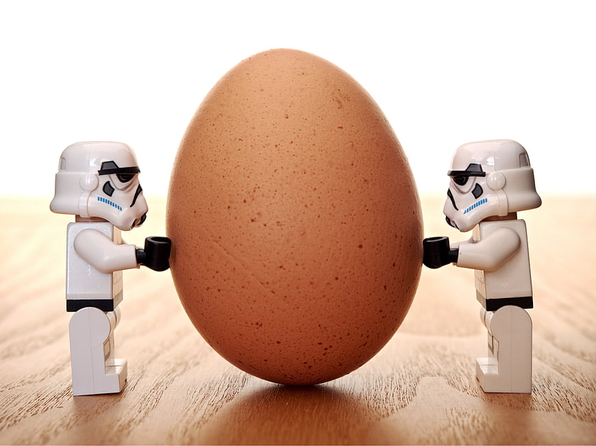 Two Lego Stormtroopers Pushing a Large Brown Egg