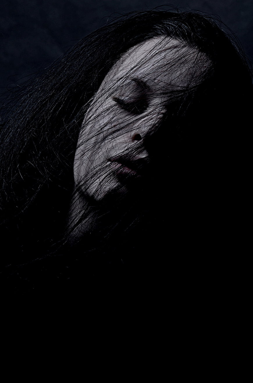 Moody Portrait of Woman With Dark Hair Covering Face