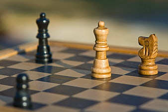 Close-up of wooden chess pieces on a checkered board
