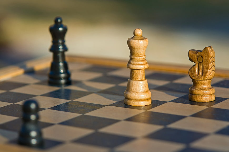 Close-up of wooden chess pieces on a checkered board