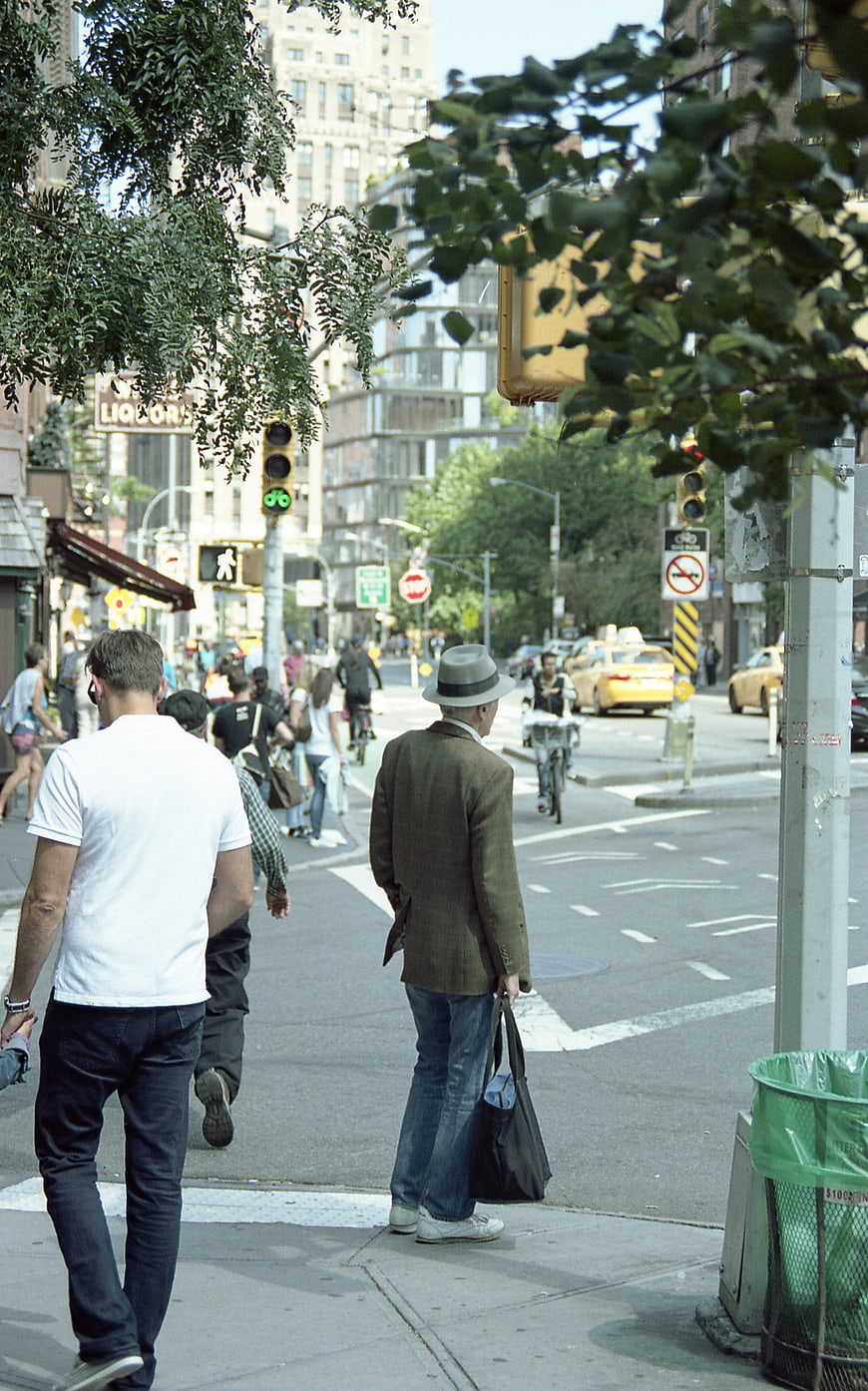 Pedestrians waiting at a busy city street corner