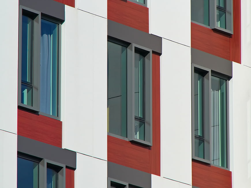 Modern building facade with red and white panels and windows