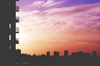 Silhouette of City Skyline Against Vibrant Pink and Purple Sunset Sky