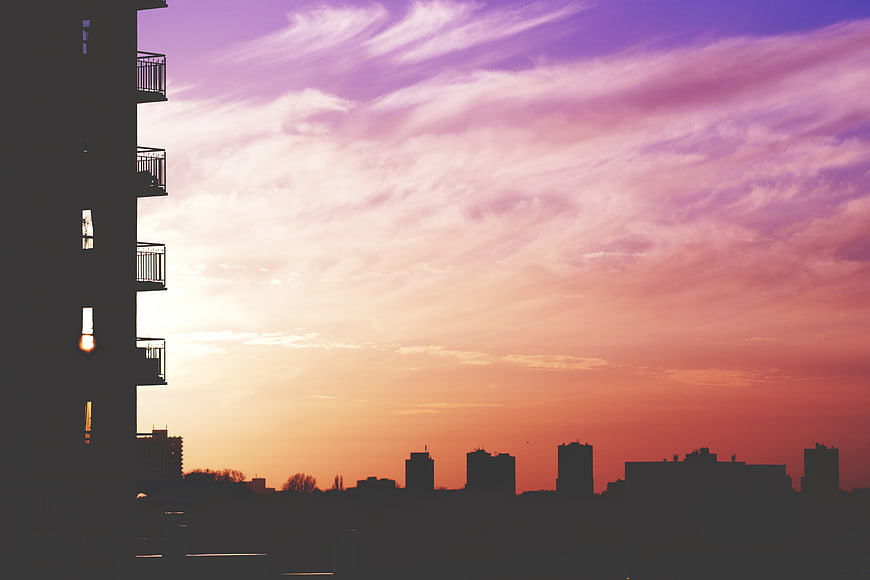 Silhouette of City Skyline Against Vibrant Pink and Purple Sunset Sky