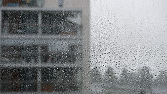 Raindrops on Window Glass with Blurred City Background