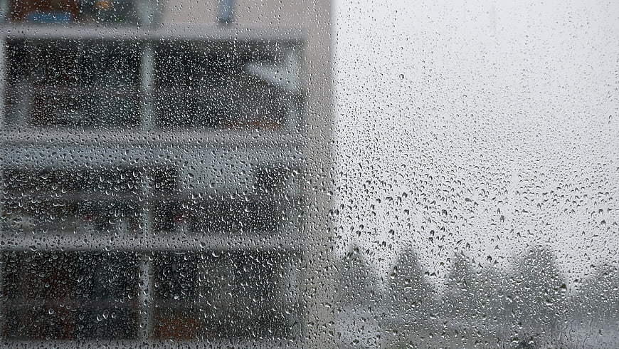 Raindrops on Window Glass with Blurred City Background
