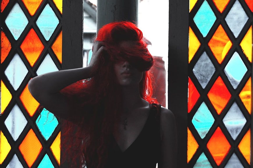 Woman with Red Hair in Front of Stained Glass Window