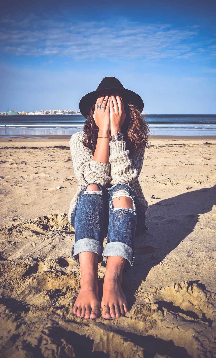 Woman Hiding Face on Sandy Beach