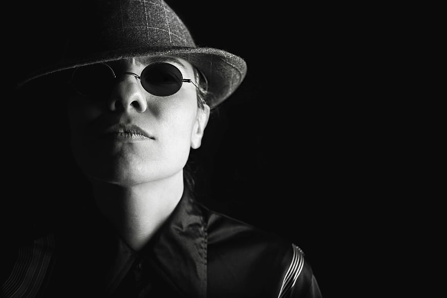 Mysterious woman in hat and sunglasses noir portrait