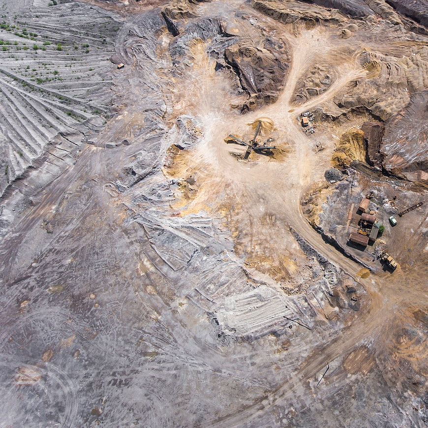Aerial view of open-pit mine with heavy machinery and excavation
