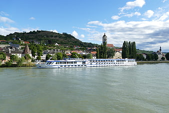 River cruise ship sailing past historic European town on the Danube