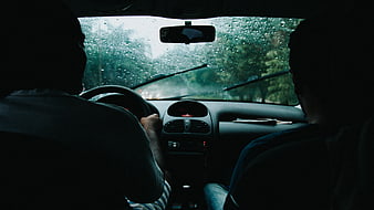 Silhouettes of Two Men Driving in Rainy Car Interior