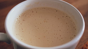 Close-up of frothy coffee in a white ceramic mug