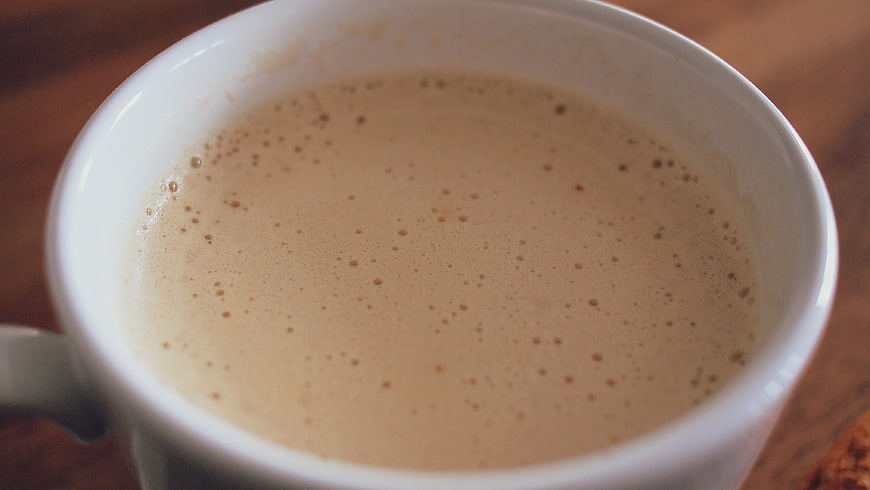 Close-up of frothy coffee in a white ceramic mug