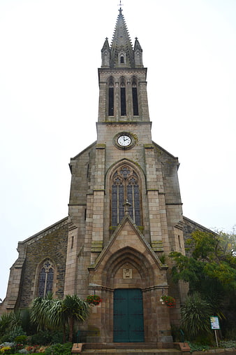 Historic Gothic Stone Church Facade With Bell Tower And Green Door