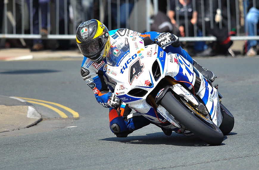 Motorcycle racer leaning into a curve on a race track