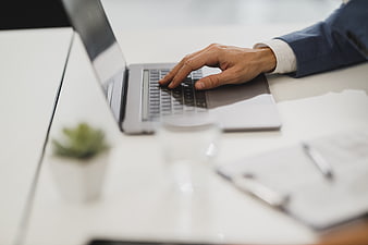 Close-up of Businessman Typing on Laptop in Office