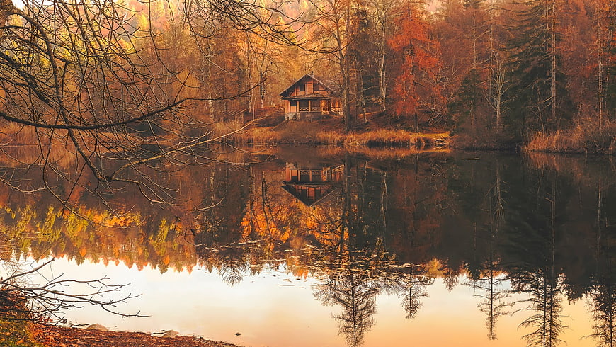 Serene Autumn Cabin by Lake with Vibrant Forest Reflections