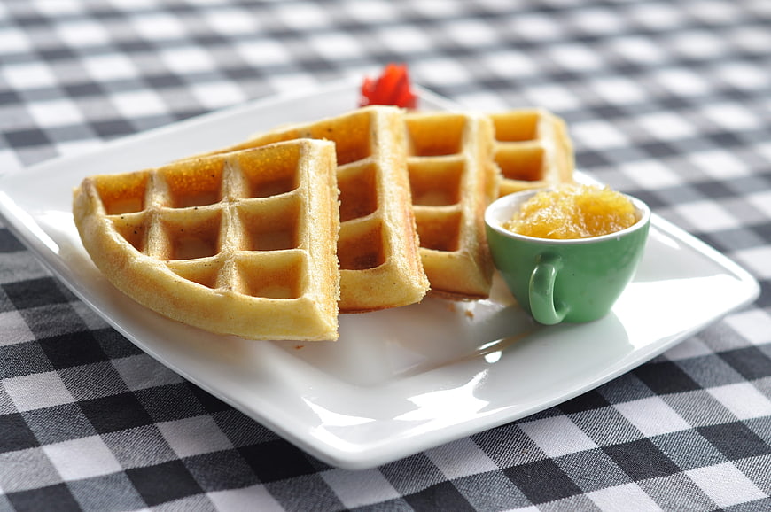 Golden Waffles with Honey on Checkered Tablecloth