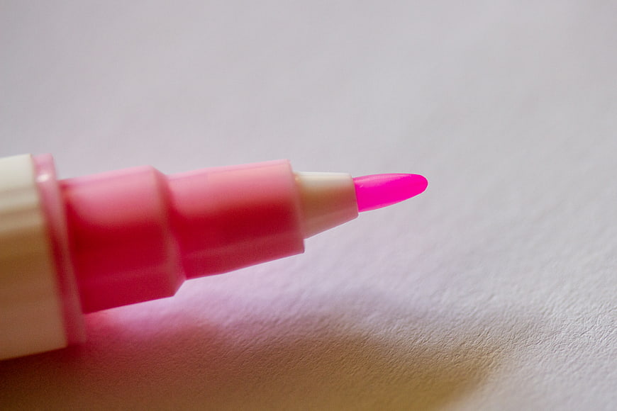 Close-up of pink highlighter tip on white paper