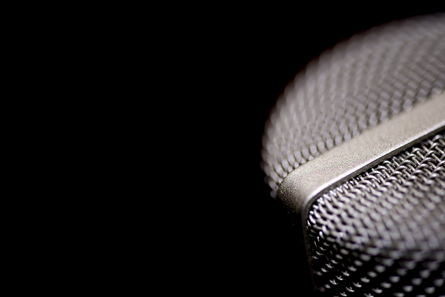 Close-up of silver microphone grill on black background
