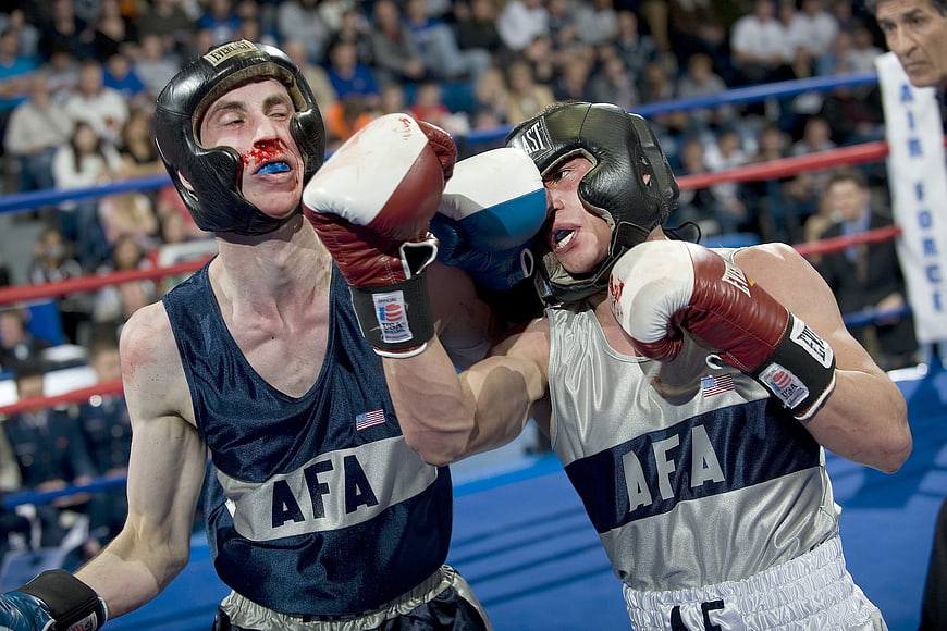Amateur boxers fighting in the ring with headgear