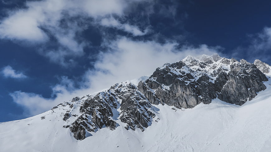 Snowy Mountain Peak with Blue Sky and Clouds