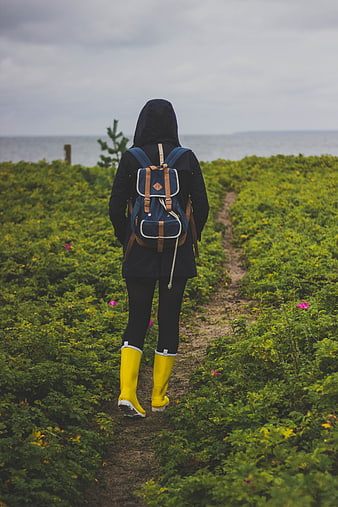 Woman in Yellow Boots Walking on Coastal Path
