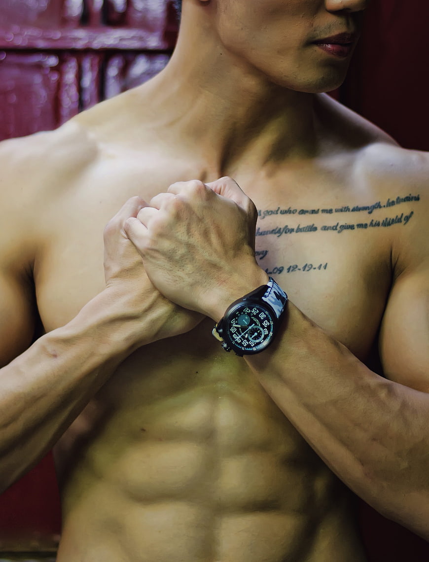 Muscular Shirtless Man with Watch and Chest Tattoo