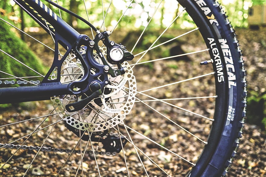 Close-up of mountain bike rear wheel and disc brake in forest