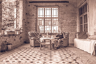 Man relaxing in vintage rustic room with exposed brick walls