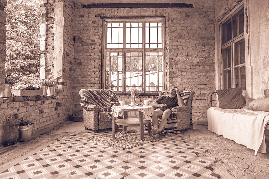 Man relaxing in vintage rustic room with exposed brick walls