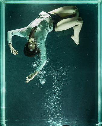 Woman Floating Underwater in Tank with Bubbles