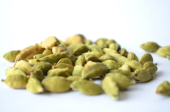 Pile of Green Cardamom Pods on White Background