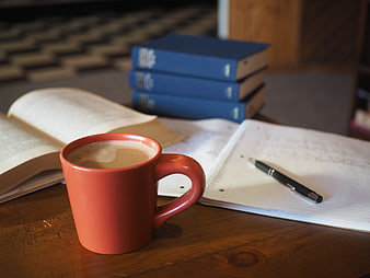 Red Coffee Mug On Wooden Desk With Books And Notebook