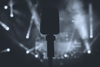 Retro Microphone Silhouette Against Blurred Stage Lights