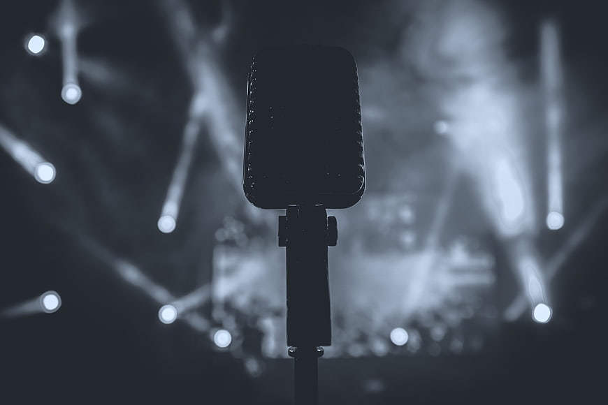 Retro Microphone Silhouette Against Blurred Stage Lights