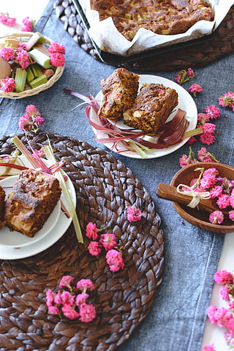 Homemade rhubarb cake with pink flowers on rustic table