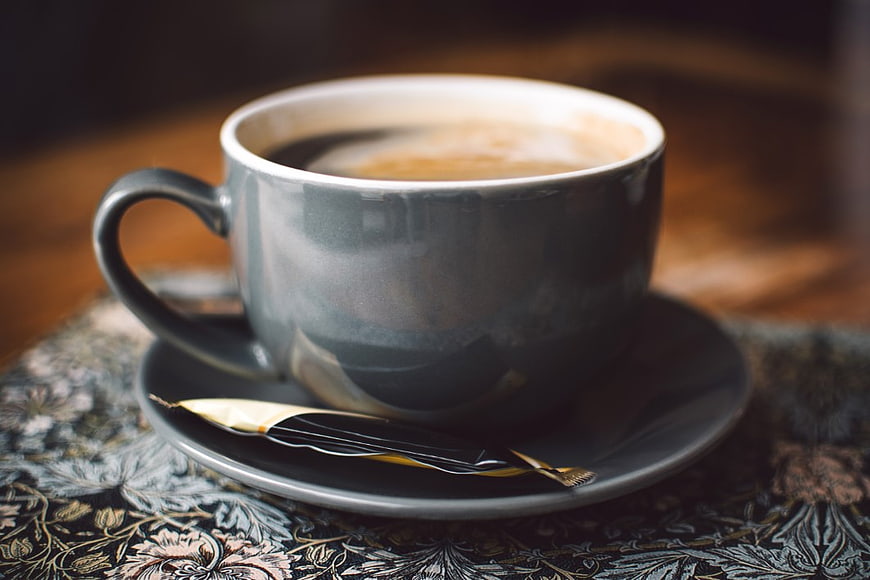 Dark Grey Coffee Cup on Floral Tablecloth