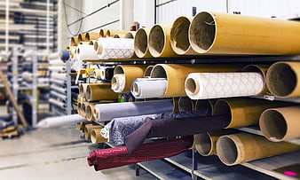 Rolls of patterned fabric on industrial warehouse shelves