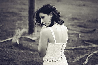 Woman in white lace dress looking back in black and white