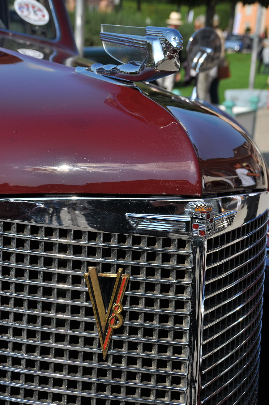 Close-up of vintage red Cadillac V8 grille and hood ornament