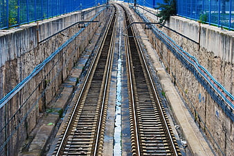 Symmetrical view of empty train tracks in concrete trench